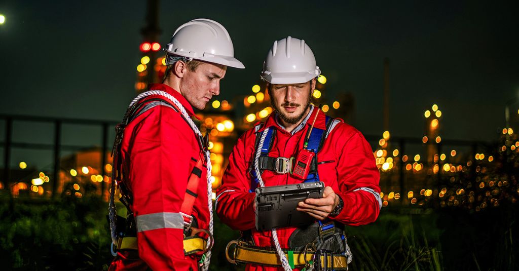 Two men looking at a rugged tablet.